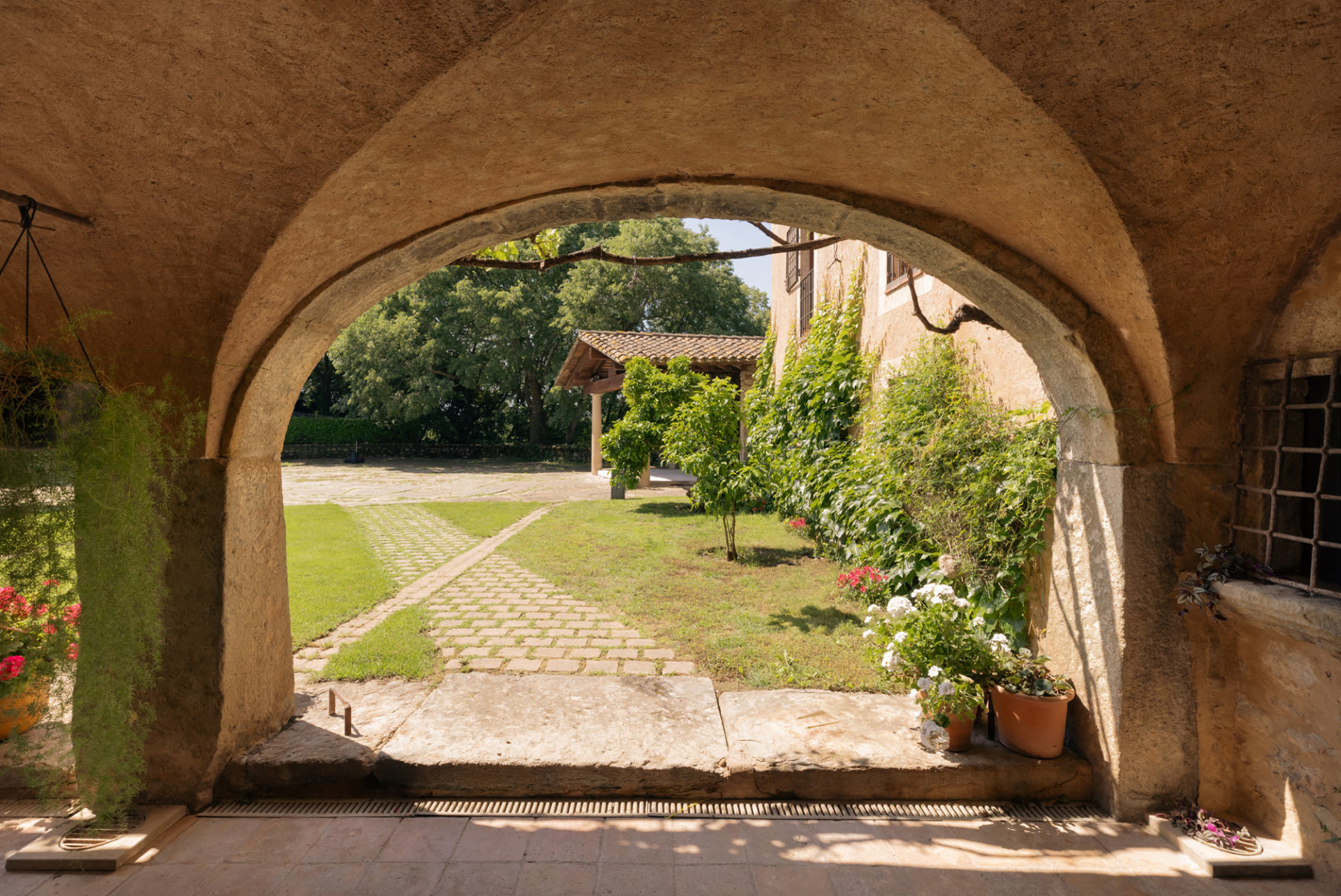 Stone arch opening onto the garden at Mas Simon