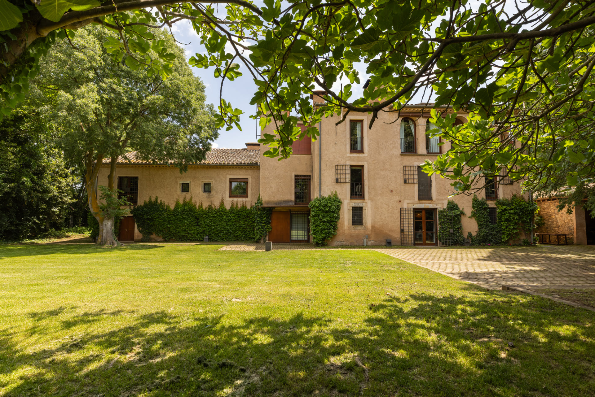 Farmhouse and shaded lawn at Mas Simon