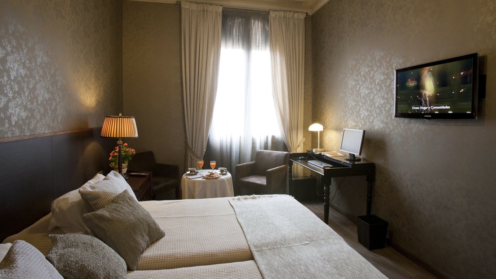Double bedroom with bedside lamps at Via Laietana